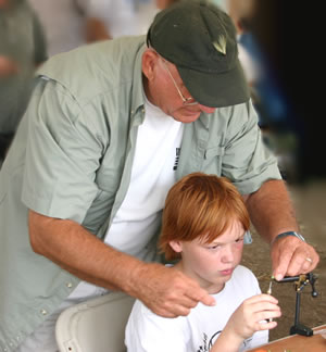 Billy Wofford assists a youngster in tying a fly